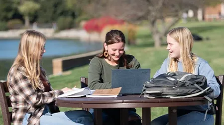 三个女大学生在外面的桌子上学习